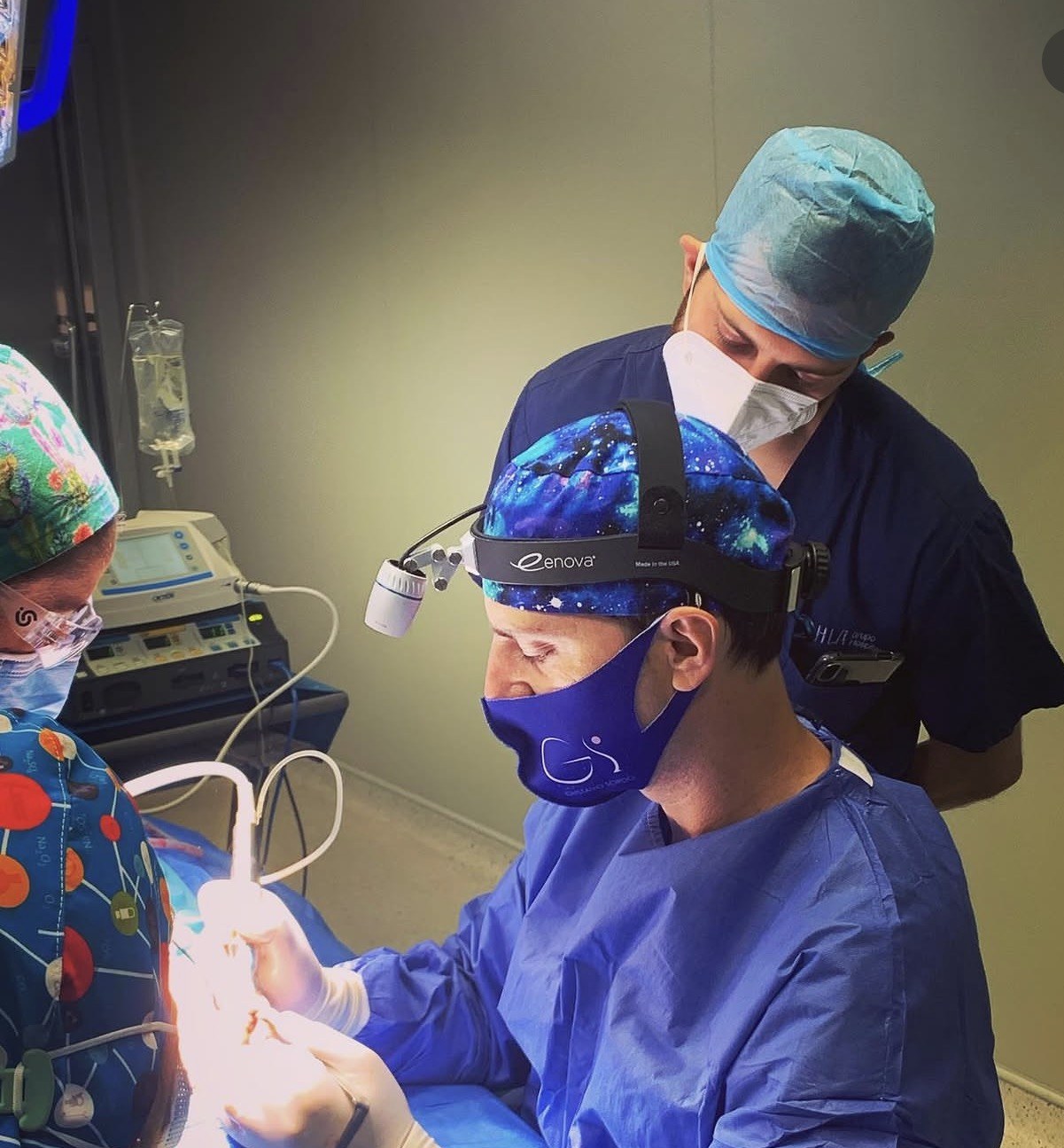 El Dr. Gustavo Sordo operando una rinoplastia en quirófano con un cirujano visitante observando la técnica