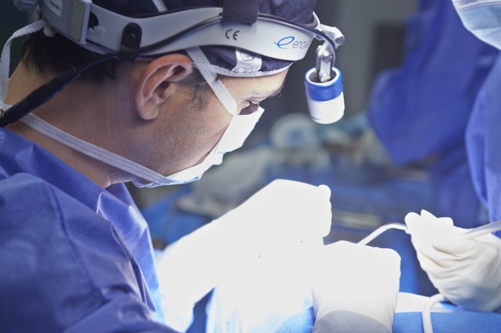 El Dr. Gustavo Sordo, cirujano plástico, operando en quirófano con luz frontal